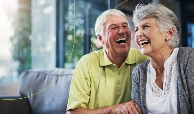 Happy senior couple laughing together in a bright living space