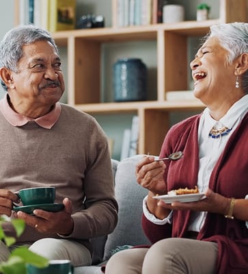 Happy seniors enjoying coffee and dessert in a common area