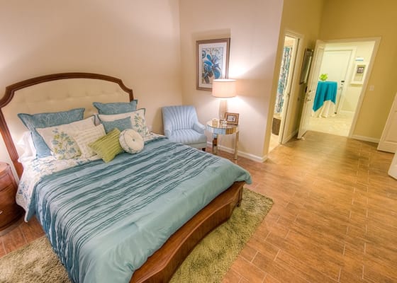 Well-decorated private resident room with bed and seating area