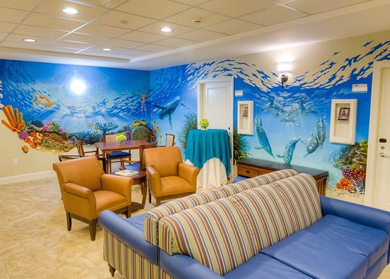 Lounge area with colorful ocean mural and seating