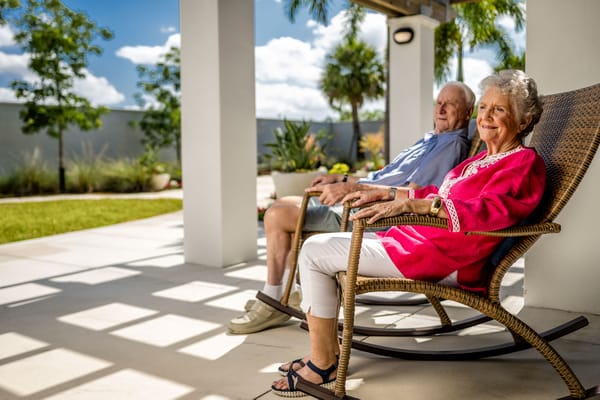 Residents enjoying the outdoor space in rocking chairs