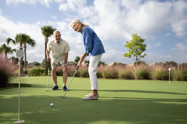 Residents enjoying a game of putting on a green lawn