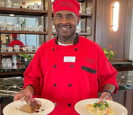 Chef holding plates of food in the dining area
