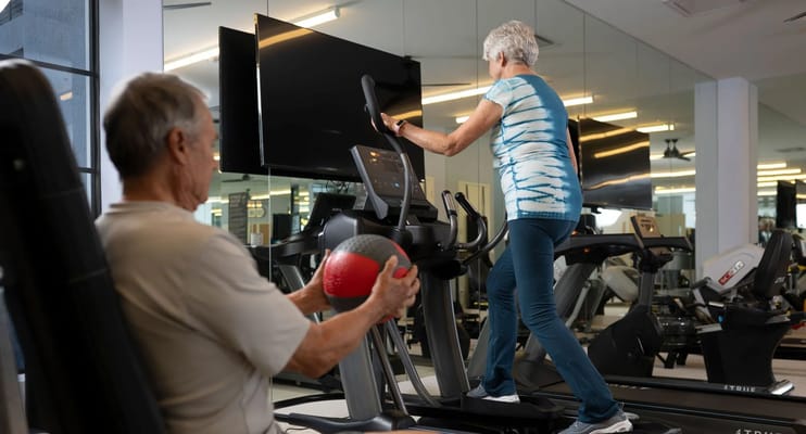 Residents exercising in a fitness area with machines