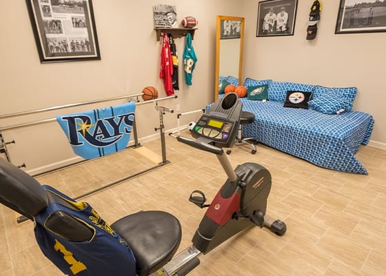 A fitness area with exercise equipment and sports memorabilia