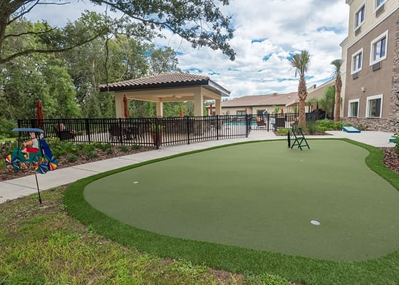 Outdoor landscaped area with putting green and seating