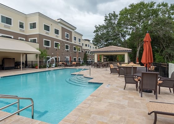 Outdoor pool area with seating and umbrellas
