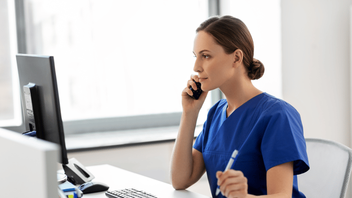 Nurse on the phone at a desk in the facility