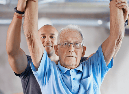 Senior resident engaged in activity with staff support