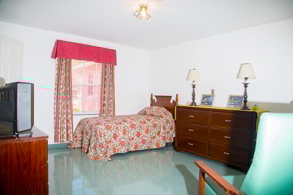 Cozy resident room with floral bedding and furniture
