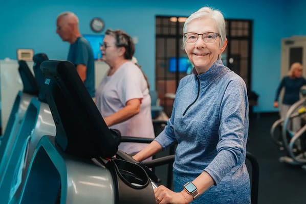 Residents exercising on fitness equipment in a gym