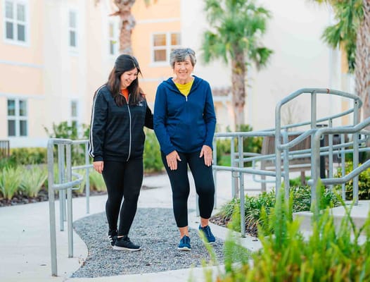 Resident and staff walking in the garden area