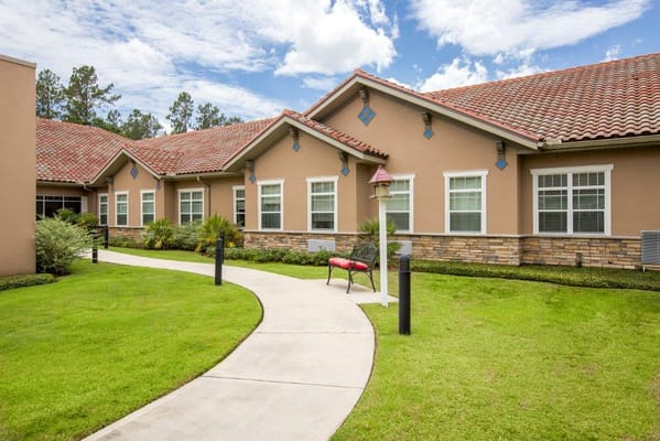 Exterior view of the assisted living facility with landscaped pathway