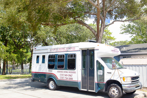 Facility shuttle bus parked in a shaded area