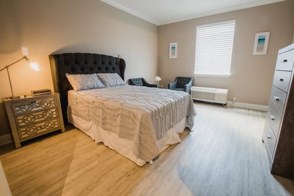 A well-furnished private resident room with a bed and seating