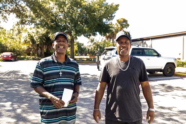 Two residents smiling outdoors in a sunny environment
