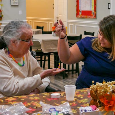 A staff member engaging with a resident during an activity