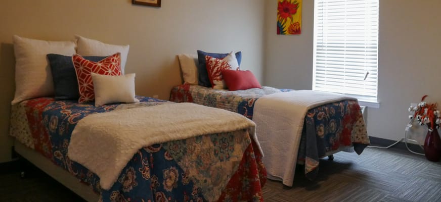 Cozy resident room with two beds and decorative pillows