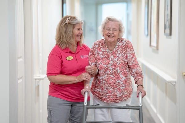 Staff assisting a resident in a hallway