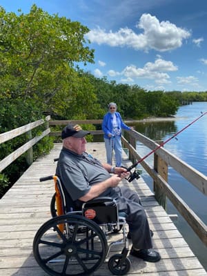 Residents fishing on a wooden pier by the water