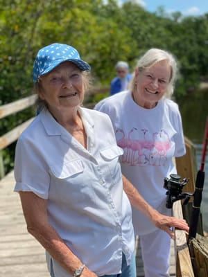 Two seniors enjoying a fishing outing on a dock