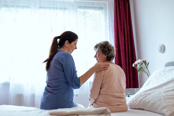 Staff member assisting a resident in a bright room