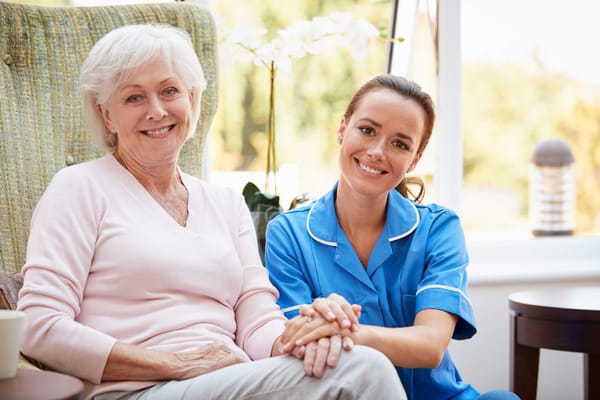 Caregiver and resident smiling together indoors