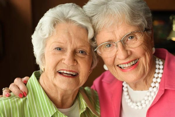 Two smiling senior women posing together
