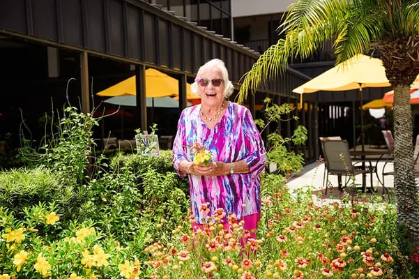 Resident enjoying the flower garden at the facility