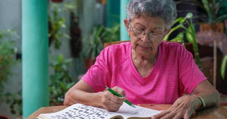 Senior resident working on a crossword puzzle indoors