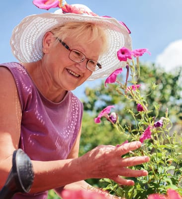 Resident gardening with colorful flowers in a sunny outdoor space