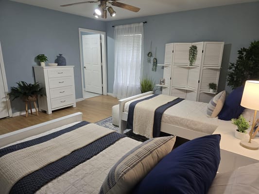 A cozy shared resident room with two beds and decor.