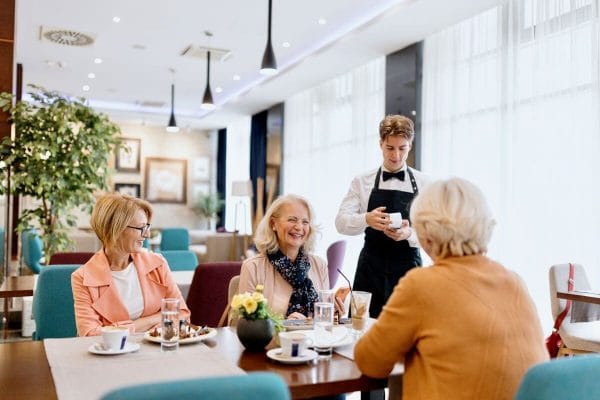 A dining room scene with residents and staff enjoying a meal
