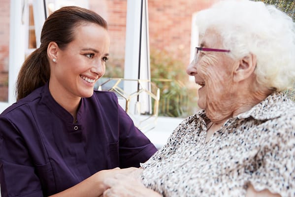 Staff member engaging with a smiling resident