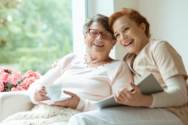 A caregiver and resident smiling together indoors