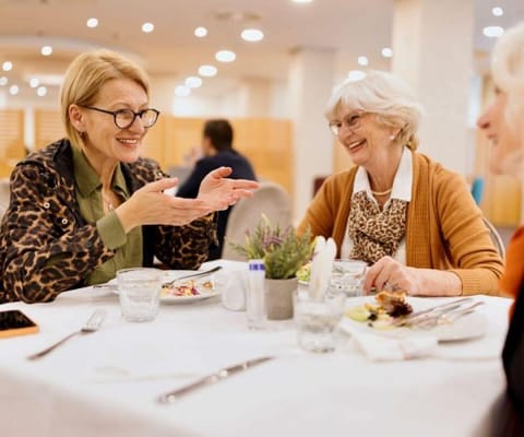 Residents enjoying a meal together in the dining room