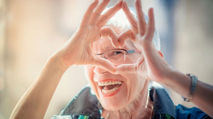 Senior woman making a heart shape with her hands