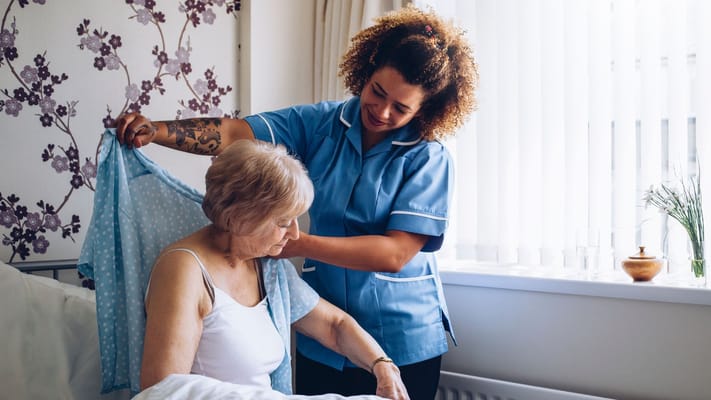 Caregiver assisting a senior resident in a bright room