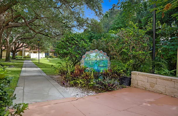 Colorful garden sign with lush greenery path
