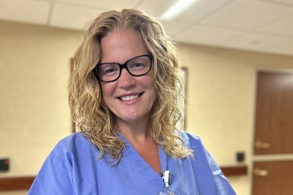 Nursing staff member smiling in the facility hallway