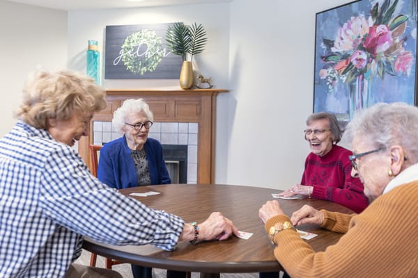 Residents playing cards in a cozy common area