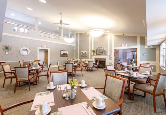 Bright dining room setup with tables and flowers