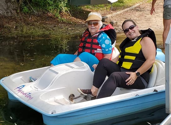 Residents enjoying a paddleboat activity on a sunny day