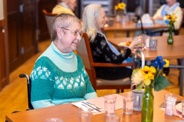 Resident enjoying dining with flowers on the table