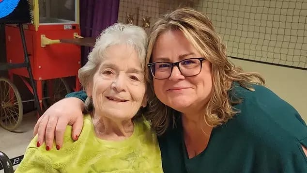 Resident and staff member smiling together