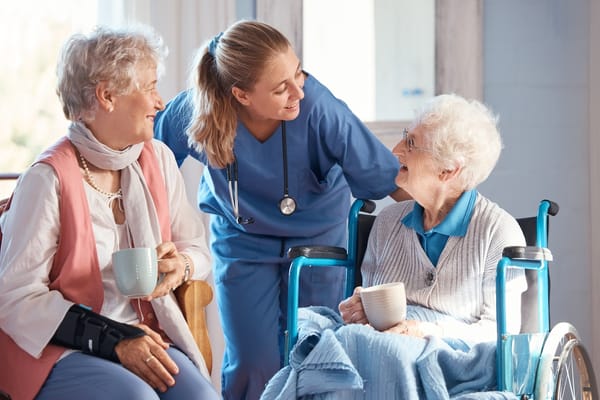 Caregiver interacting with smiling residents in a lounge area