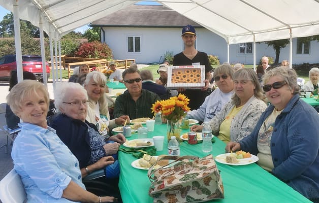 Residents enjoying a meal outdoors at a celebration event