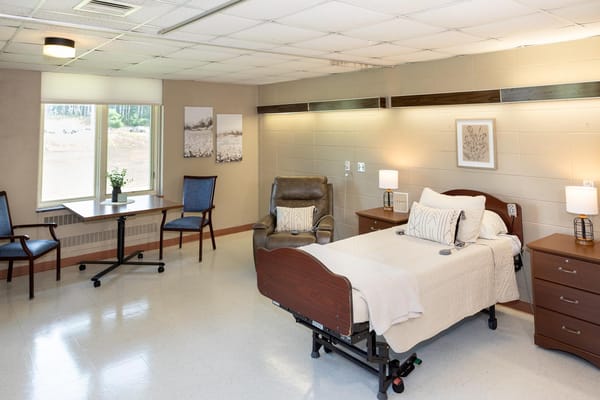 Bright private resident room with bed and sitting area