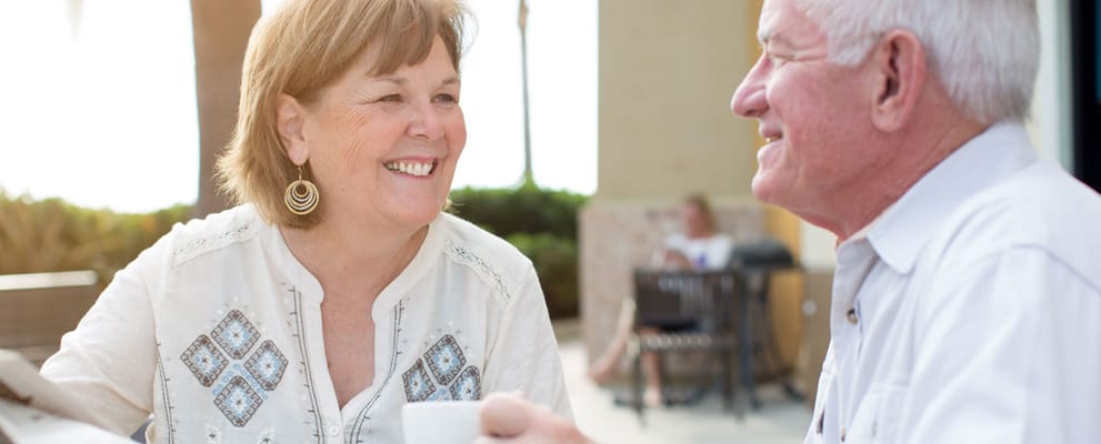 Two seniors enjoying coffee outdoors