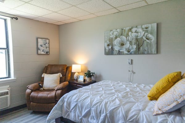 Cozy private resident room with a bed and seating